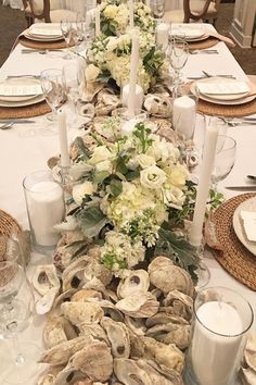 a long table is set with white flowers and candles for an elegant centerpieces