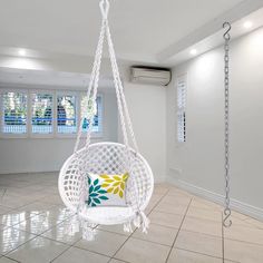 a white hanging chair in the middle of a room