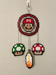 the pixel art is hanging on the wall next to other items that have been made out of beads