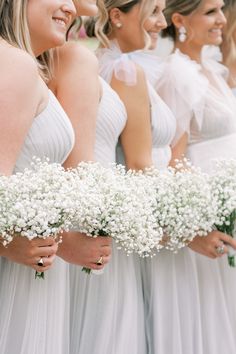 the bridesmaids are holding bouquets of baby's breath