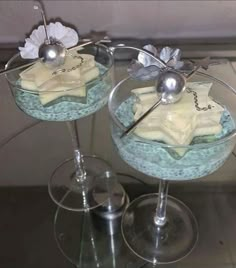 two glasses with dessert items in them on a table