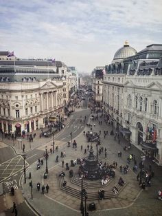 an aerial view of a city square with people walking around