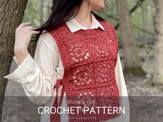 a woman standing next to a tree wearing a red crochet vest