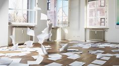 an empty room with many pieces of paper on the floor