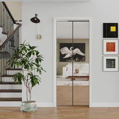 a living room with stairs and pictures on the wall