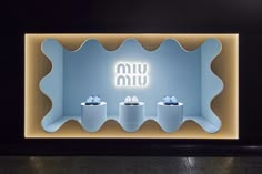 an illuminated display case with three rolls of toilet paper on it's sides and the words yum written above them