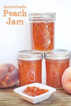 peach jam in mason jars on a wooden table with peaches next to it and two peach halves