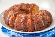 a bundt cake on a white plate with blue and white checkered table cloth