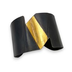 Gold & Steel Bracelet - This sculptural steel cuff boasts a striking contrast in both color and texture that creates a play of light, enhancing its curved, ribbon-like form with a smooth, gently flowing black surface. The top of the cuff features lustrous 24k gold foil applied using a variation of the ancient Korean technique of Keum-Boo. Modern Evening Cuff Bracelet Bangle, Modern Twist Cuff Bracelet For Formal Occasions, Modern Evening Cuff Bangle Bracelet, Modern Evening Cuff Bracelet, Contemporary Cuff Bangle For Formal Occasions, Modern Black Cuff Bracelet For Parties, Keum Boo, Artful Home, Steel Bracelet