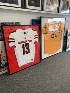 Turn your jersey in to framed wall art for your home. Black wooden jersey frame with acrylic plexiglass front for protect your jersey framing. Each framed jersey is ready to hang on your wall once’s delivered. We frame all jersey : football, soccers, baseball, wrestling, softball and we even custom frame tshirt jerseys T Shirt Frame Display, Framed Football Jersey, Framed Jersey Ideas, Frame Jersey Ideas, Jersey Display Ideas, Picture Frame Store, Jersey Frame, T Shirt Frame, Memory Design