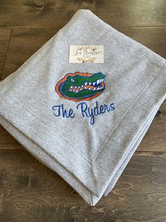 a gray sweatshirt with the words, the ryders on it and an alligator's head