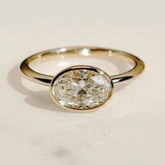 a close up of a diamond ring on a white surface