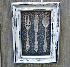 an old frame with spoons and forks in it