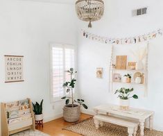 a living room with white walls and wooden floors, decorated with garlands on the ceiling