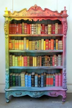 an old bookshelf is painted pink, yellow and blue