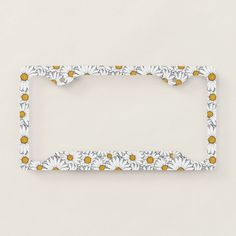 a white and yellow frame with daisies on the edge, against a beige background