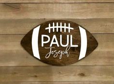 a wooden sign that says paul joseph on it with a football in the center and words