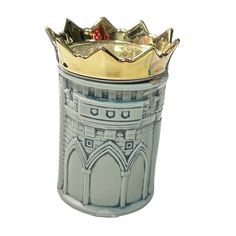 a silver and gold cup with a crown on it's top sitting in front of a white background