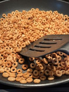 a frying pan filled with cereal and a spatula