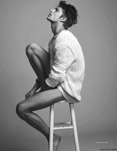 a man sitting on top of a wooden stool