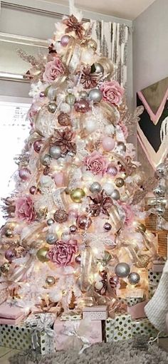 a white christmas tree decorated with pink and gold ornaments