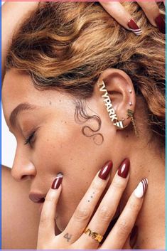 a woman with her hands on her face and ear piercings in front of her head