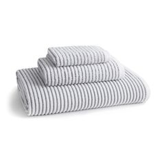 three towels stacked on top of each other in grey and white stripes, with one folded up