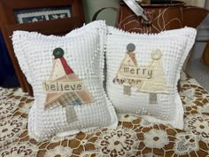 two decorative pillows sitting on top of a table