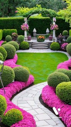 a garden with lots of green grass and pink flowers