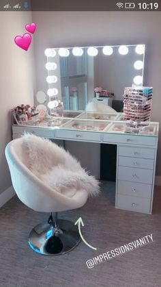 a white chair sitting in front of a table with a mirror and lights on it