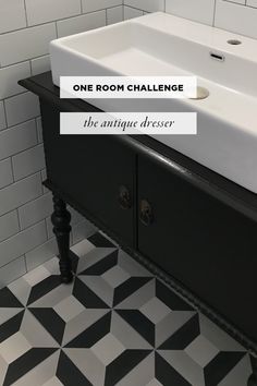 a black and white tiled bathroom with one room challenge written on the wall above the sink