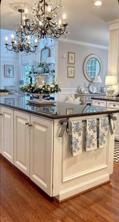 a kitchen island with towels hanging from it's hooks and lights on the ceiling