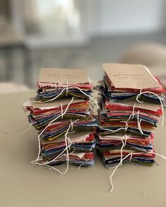 a stack of books sitting on top of a table covered in paper and twine