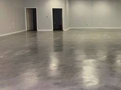 an empty room with white walls and gray flooring is seen in this image from the inside