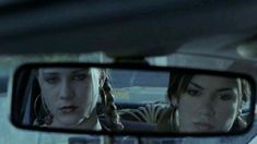 two women are seen in the rear view mirror of a car