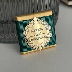 a close up of a gold and green tie on a glass vase with other items in the background