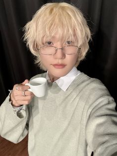 a person wearing glasses and holding a cup