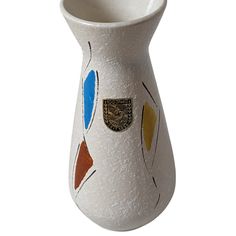 a white vase with multicolored designs on it