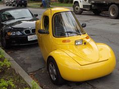 a small yellow car parked next to a black car