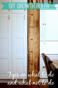 a tall wooden ruler sitting on top of a table next to a white cupboards