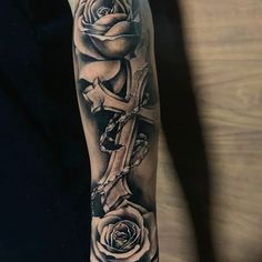 a person with a cross and roses on their arm