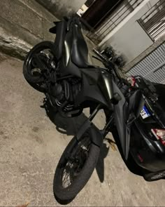 a black motorcycle parked next to a building