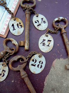 old rusty keys with numbers on them are laying next to a ruler