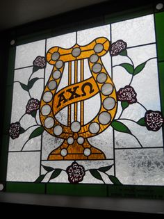 a stained glass window with the word tax written on it and flowers in the background