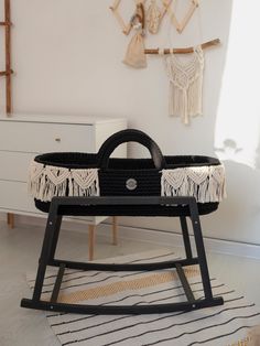 a black and white baby crib in a room with wall hangings on the wall