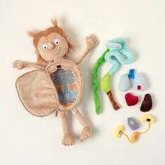 a stuffed animal is laying next to some toy items on a white surface with one arm in the air