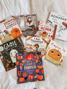 several children's books laid out on a bed with the covers pulled back to show them