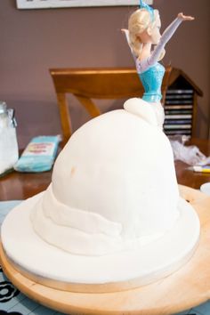 there is a cake that looks like a ballerina on top of a snow globe