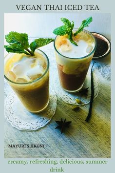 two glasses filled with ice tea sitting on top of a table