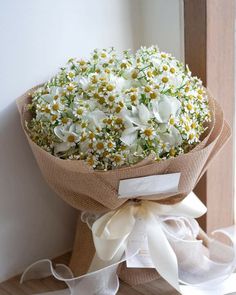 a bouquet of white flowers wrapped in burlock